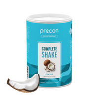Ein blauer Behälter mit „Precon Complete Shake Cocos“ steht aufrecht, davor liegt ein Stück Kokosnuss. Auf dem Etikett ist ein Kokosnuss-Motiv zusammen mit Produktinformationen abgebildet.