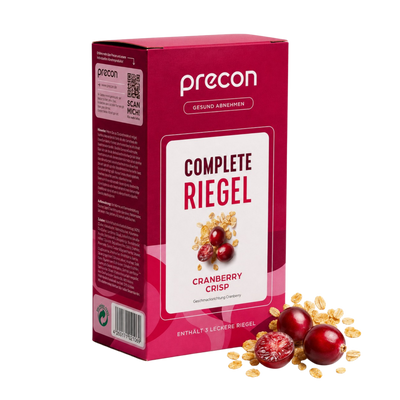 Zu sehen ist eine rote Verpackung der „Complete Riegel CranberryCrisp“-Riegel der Anona GmbH, auf deren Verpackung Cranberries und Getreideflocken abgebildet sind. Neben der Verpackung liegen frische Cranberries und Getreideflocken.