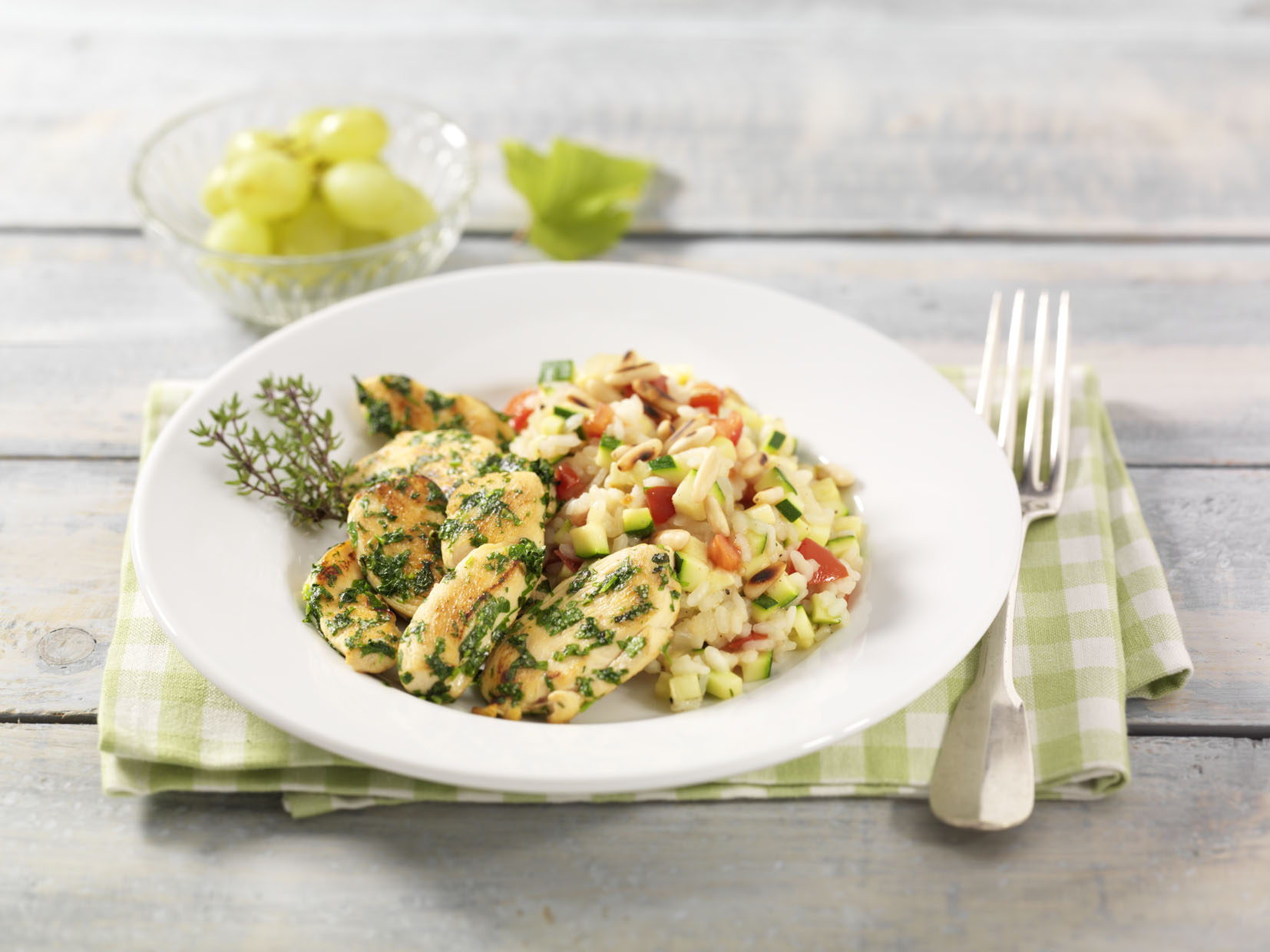 Kräuter-Hähnchenbrustfilets mit Zucchini-Tomaten-Risotto und Pinienkernen